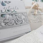 Wegner wedding - close up of stationery examples - Bride and Groom's initials in precision cut belly band and pocket sleeve